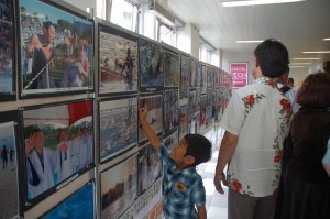 駅構内の壁面いっぱいに宮古島大会の写真パネルが張り出された＝26日、那覇市、ゆいレール県庁前駅