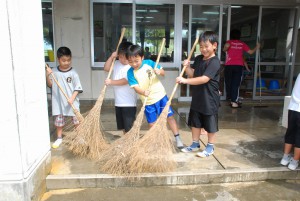 掃き掃除をする子どもたち＝１日、東小学校