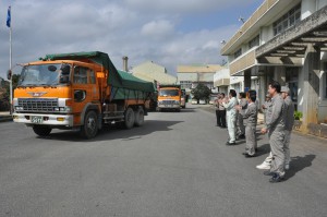 分蜜糖を積んだトラックを拍手で見送る工場職員ら＝21日、宮古製糖城辺工場