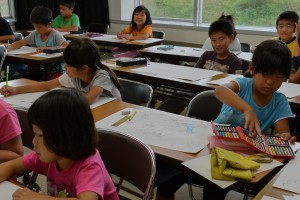 画用紙に夏休みの楽しい出来事などを描く児童＝２日、上野公民館