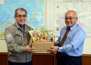 安村社長（左）が下地市長に２０１３年産の多良間産黒糖を使用した商品を贈呈し、そのおいしさをＰＲした＝21日、市役所平良庁舎