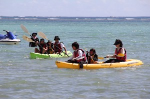 シーカヤックを楽しむ参加者たち＝18日、高野漁港西の浜