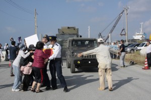 ミサイル発射機などを積んだ自衛隊車両を阻止しようとする市民団体のメンバーら＝６日午前、平良港下崎埠頭
