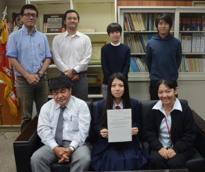砂川校長（手前左）らが沖縄県立看護大学に合格した下地さん（同中央）をたたえていた＝18日、伊良部高校