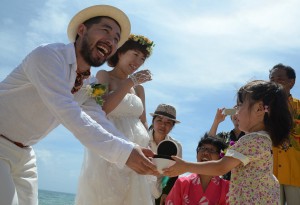 南さん夫婦は女の子から結婚指輪を受け取り、互いにはめて永遠の愛を誓った＝２８日、来間島のムスヌン浜