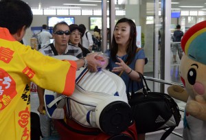 東京直行便の来島者に大きな宮古島産マンゴー１個がプレゼントされた＝１２日、宮古空港