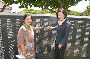 刻銘された母親の名前をなぞる狩俣さん（左）と砂川さん（右）の姉妹＝２３日、糸満市の「平和の礎」