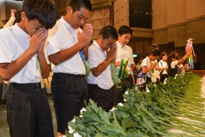 児童生徒たちが献花を行い、戦没者のみ霊を慰め、恒久平和を祈念した＝２３日、マティダ市民劇場
