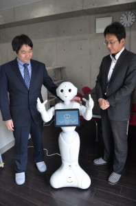 感情を持ったパーソナルロボット「ペッパー」（中央）と高柳社長（右）。左は技術担当の橋口智哉さん＝１８日、セルリアンネット