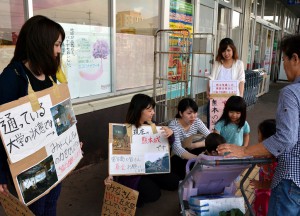 街頭募金活動を継続している学生たち＝２３日、市内スーパー前