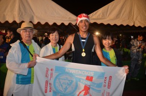 初出場で完走し、家族の祝福を受けた小松さん（左から３人目）＝１７日、市陸上競技場