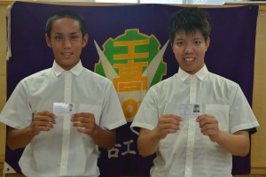 「工事担任者」資格者証を手に喜ぶ（左から）狩俣君と下地君＝２９日、宮古工業高校