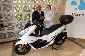 電動二輪車のエコ貢献に期待を寄せた下地市長（左）と松良社長＝６日、市内ホテル
