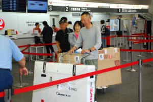 バイクなどの荷物を係員に預ける選手＝16日、宮古空港