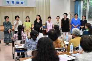 総会であいさつに立つ新会長の新城美津枝さん（左から２人目）＝２７日、働く女性の家