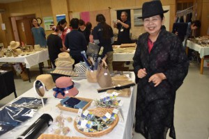 「すだーすぬぬ」の洋服を着た女性は、試しに帽子をかぶった＝３日、市伝統工芸センター