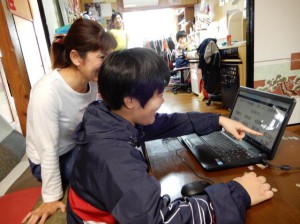 インターネットで合格番号を見つけ喜ぶ親子＝11日、市平良