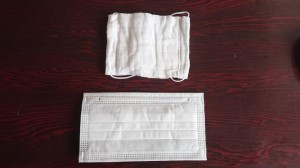 小さく使いづらいとの声が上がる国が介護施設などに配布した布マスク（上）と市販されている使い捨てマスク（下）