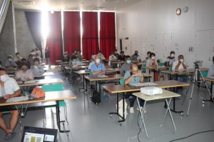 陣地壕など戦争遺跡について説明を聞く市民ら＝11日、市未来創造センター