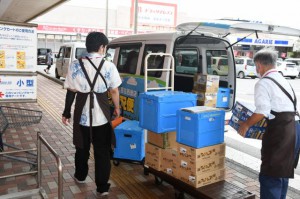 ネットで注文を受けた商品を配送するため車に積み込む店舗担当者＝28日、平良西里