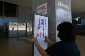 建物入り口に臨時休館の告知文を張り付ける職員＝７日、市未来創造センター