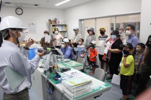 ごみ処理の様子を映し出したモニターを見ながら説明を聞く市民ら＝10日、市クリーンセンター