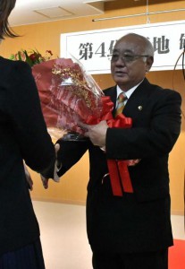 退任式で職員から花束を受け取る下地市長＝22日、市役所