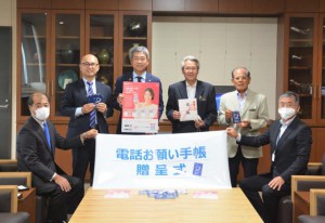 畔上支店長（後列左から２人目）から座喜味市長（同３人目）へ目録が贈られた＝８日、市役所