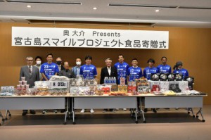 名波さん（前列左から４人目）らが食品を届けた＝９日、市役所