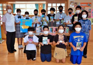 本を寄贈した佐和田さん（右端）＝21日、伊良部島小・中学校