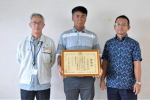 農林水産大臣感謝状を手にする久高さん(中央)=18日、宮古島漁業協同組合