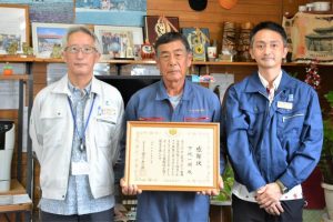 粕谷センター長(左)から下地さん(中央)に感謝状が贈られた=18日、下地洲鎌
