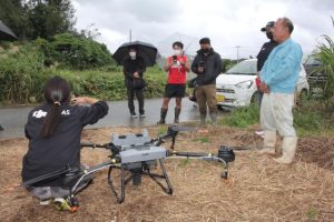 農業ドローンによる作業を事業化する辺土名さん（右）＝13日、平良狩俣