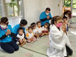 元気に成長することを願って祈願する園児ら＝12日、多良間神社