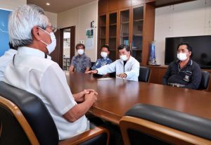 座喜味市長（手前）に旧事務所の解体と水産加工施設の建設を要請する與那嶺組合長（奥右から２人目）＝16日、市役所