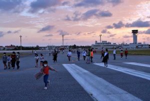 ３０００㍍の滑走路を目の当たりにして、その広大な風景に喜ぶ参加者たち＝６日、下地島空港