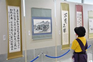 展示された作品に見入る市民＝11日、市中央公民館玄関ロビー
