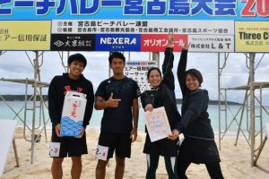 優勝を喜ぶハイサイのメンバー。（左から）天願さん、呉屋さん、高良さん、上地さん＝14日、下地の与那覇前浜ビーチ