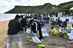 市職員や一般ボランティアらが参加して軽石を集めた＝19日、浦底海岸