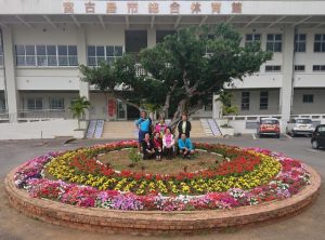 円形の花壇に植えた花が満開となり大喜びの役員ら＝17日、市総合体育