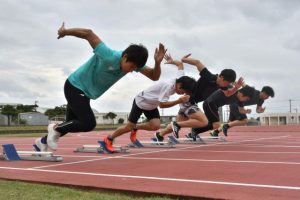 スタートを練習する飯塚選手（左）ら＝５日、市陸上競技場