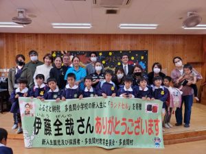 伊藤さんから贈られたランドセルを背負い笑顔の子供たちと保護者ら＝多良間幼稚園