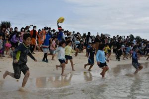 一斉に海に飛び込む子供たち＝19日、与那覇前浜ビーチ