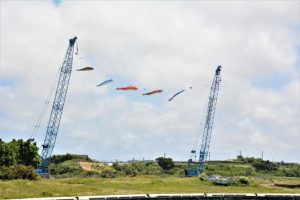 大型重機を使ってこいのぼりが掲揚されている＝29日、久松漁港