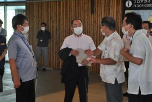 関係者から説明を受ける西銘大臣(中央)=20日、下地島空港