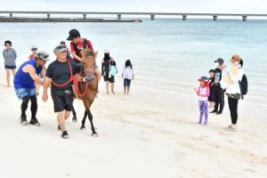 乗馬体験では多くの子供たちが笑顔を見せていた＝26日、下地与那覇の前浜ビーチ