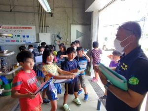 浄水場の役割などについて清村さん（右）から説明を受ける児童たち＝村仲筋にある浄水場