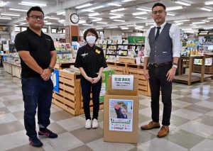 取り組みに賛同した野津社長（右）が富山社長（左）に協力を打診し、制服の回収ボックスが設置された＝22日、ＴＳＵＴＡＹＡ沖縄宮古島店