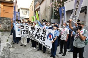 暴力団員の事務所として使用されていた場所でシュプレヒコールを上げる参加者ら=31日、平良西里