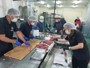 提供を受けたマグロをさばく調理師会のメンバー＝27日、宮古島漁協